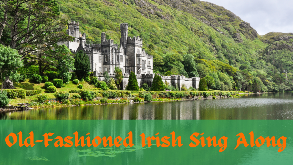 An irish castle next to water, with green mountains as it's backdrop